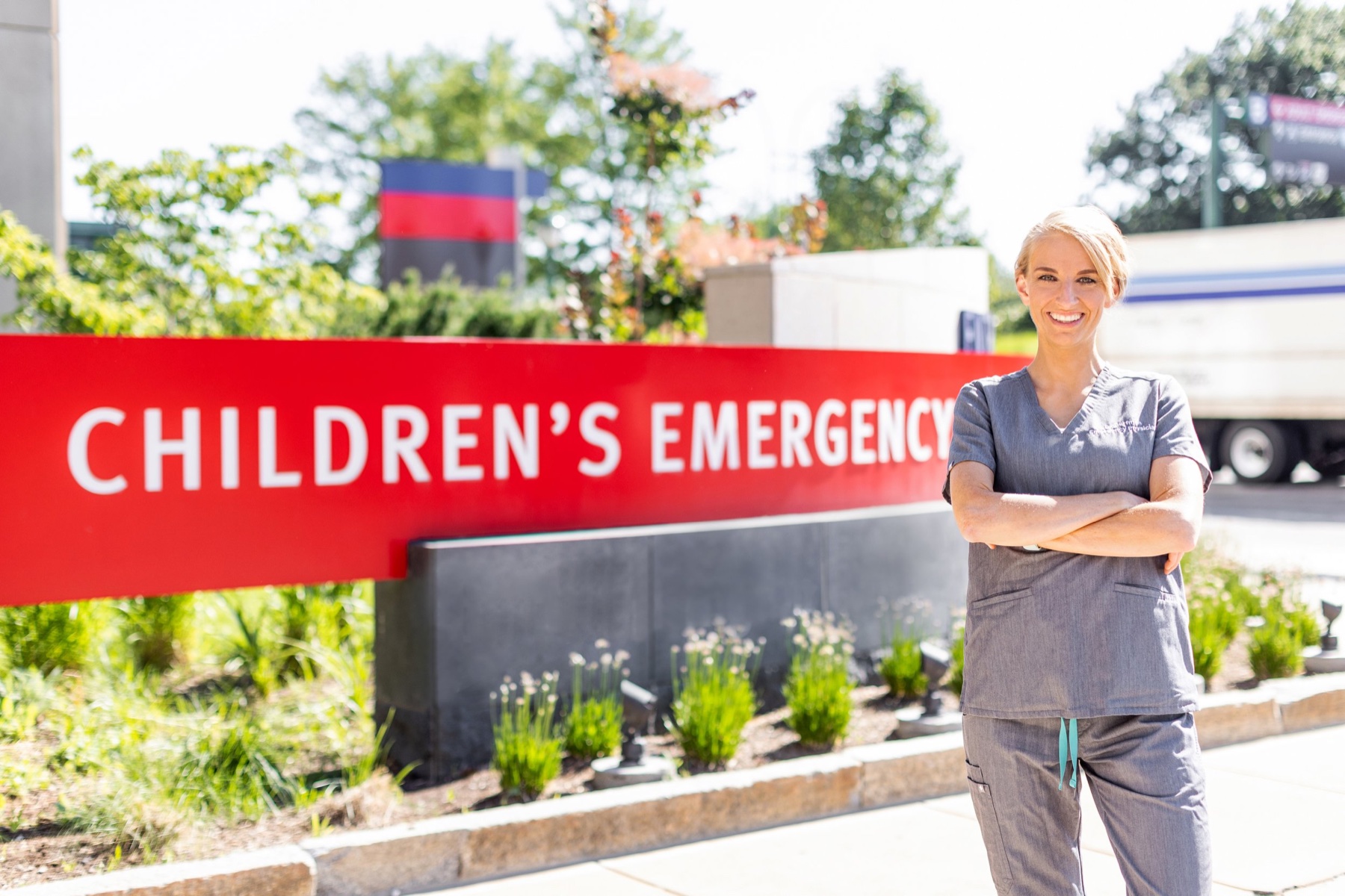 Alison Curfman, MD, in scrubs outside a children's emergency department